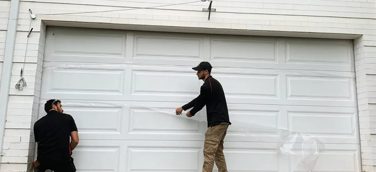 Alt Text: "Orlando FL Quick Garage Door and Gate Repair - Expert technician fixing a residential garage door with precision tools, enhancing home security and efficiency."